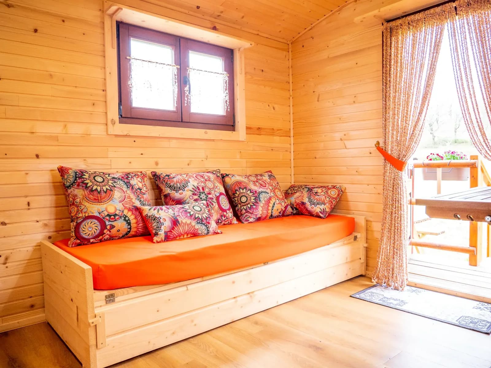 Interior acollidor de roulotte amb vistes a la terrassa, allotjament Pirineus