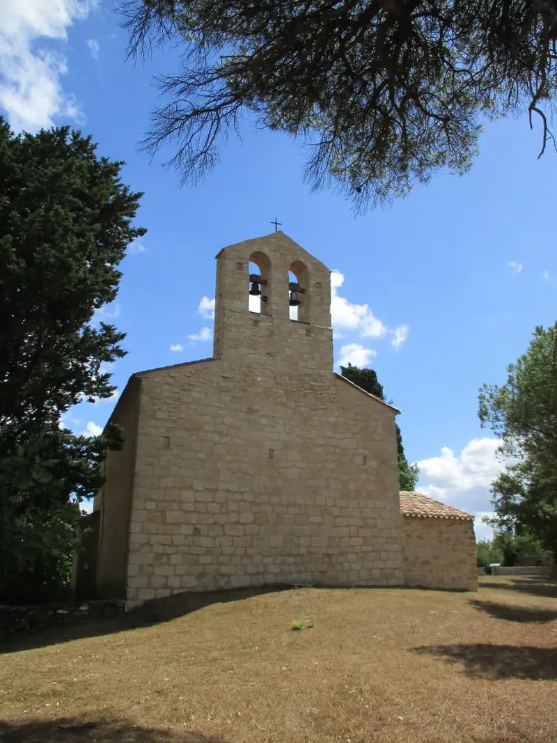Chapelle de Sainte-Foi en Ariège au printemps, entourée de prairies fleuries et de Pyrénées